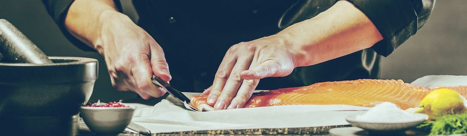 Professional chef filleting salmon.