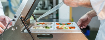 Packing food in heated trays.